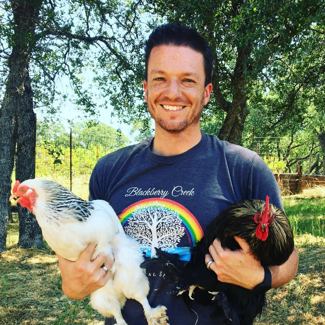 Joshua Hanosh holding two rescued chickens, Lucas and Peep.